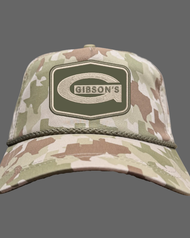 A camouflage baseball cap featuring a prominent Gibson's logo patch on the front, set against a plain white background.