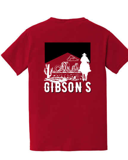 A red short-sleeve t-shirt shown from the back, featuring a white and black graphic of a desert landscape with a cowboy silhouette and the text 'GIBSON S'.